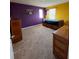 This bedroom features a large window, neutral carpet, and is finished with a yellow and purple color scheme at 144 Bella Dr, Davenport, FL 33837