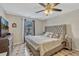 Bright bedroom featuring a tufted headboard, large window and tile flooring at 1464 Howland Blvd, Deltona, FL 32738