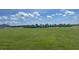 A greenfield space with community amenities in the distance under a partly cloudy sky at 1827 Silverbell Loop, Haines City, FL 33844