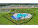 Aerial view of the community pool with lounge chairs and picnic tables with sunshades at 1827 Silverbell Loop, Haines City, FL 33844