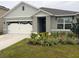 Inviting single-Gathering home featuring a two-car garage, enhanced landscaping, and an attractive entrance at 1827 Silverbell Loop, Haines City, FL 33844