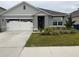 Attractive single-story home features an attached garage, decorative landscaping, and a welcoming front entrance at 1827 Silverbell Loop, Haines City, FL 33844