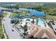 Aerial view of the community water park, clubhouse, pool, and surrounding landscape with a scenic lake view at 194 Aidans Lndg, Haines City, FL 33844