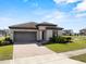 This home features a manicured lawn, a tile roof, and a two-car garage at 194 Aidans Lndg, Haines City, FL 33844