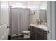 Cozy bathroom featuring a gray vanity with granite top, storage and neutral colored shower curtain at 2038 Lily Pl, Kissimmee, FL 34759