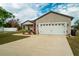 Charming single-story home featuring a well-manicured lawn, a two-car garage and inviting front porch at 2038 Lily Pl, Kissimmee, FL 34759