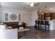 Spacious living room featuring hardwood floors, modern lighting, a leather couch, and barstool seating to the kitchen at 2038 Lily Pl, Kissimmee, FL 34759