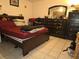 Bedroom featuring wood furniture, a large bed, tile flooring, and natural light from the window at 2227 Virginia Dr, Kissimmee, FL 34741