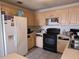 Traditional kitchen featuring wooden cabinets, black appliances, and white refrigerator at 2227 Virginia Dr, Kissimmee, FL 34741