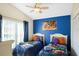 Nicely decorated bedroom with two beds, a large window, and bright blue accent wall at 226 Bailey Cir, Davenport, FL 33897