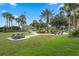 Beautiful community park featuring lush green spaces, walking paths, picnic tables, and seating under swaying palm trees at 226 Bailey Cir, Davenport, FL 33897