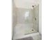 Modern walk-in shower with glass enclosure and tiled walls in neutral earth tones at 226 Bailey Cir, Davenport, FL 33897