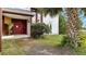 Close up of the front of the home with a red double-door entry and palm tree at 2462 Albany Dr, Kissimmee, FL 34758