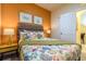 Bright bedroom with a queen bed, colorful bedding, and two leaf themed art pieces at 2725 Coupe St, Kissimmee, FL 34746