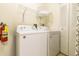 Bright laundry room features a washer, dryer, storage shelves and fire extinguisher at 2725 Coupe St, Kissimmee, FL 34746