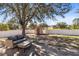 Spacious fenced backyard featuring mature trees, a storage shed, and a cozy seating area at 2938 Foraker Way, Kissimmee, FL 34758