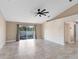 Open living room with neutral walls, tile flooring, ceiling fan, and sliding glass doors at 2938 Foraker Way, Kissimmee, FL 34758