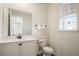 Clean, compact bathroom with a modern vanity, toilet, and a bright window at 2980 Caribbean Soul Dr, Kissimmee, FL 34747