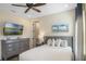 Inviting bedroom with a comfortable bed, natural light, and a large dresser with mounted TV at 2980 Caribbean Soul Dr, Kissimmee, FL 34747