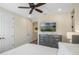 Relaxing bedroom with mounted TV, ample storage, and serene decor for a comfortable retreat at 2980 Caribbean Soul Dr, Kissimmee, FL 34747