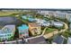 Aerial view of colorful homes and resort buildings, showcasing tropical landscaping and proximity to a lake at 2980 Caribbean Soul Dr, Kissimmee, FL 34747