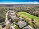 Scenic aerial view of neighborhood homes backing onto golf course and surrounding wooded landscape at 328 Hamrick Dr, Kissimmee, FL 34759