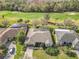 Aerial view of a well-manicured home with a screened pool, a golf course, and lush landscaping at 328 Hamrick Dr, Kissimmee, FL 34759