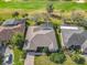 Overhead view of a home with manicured landscaping, brick driveway, and a screened-in pool, nestled by a golf course at 328 Hamrick Dr, Kissimmee, FL 34759