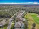 An aerial view of homes near a lush green golf course and wooded area under a blue sky at 328 Hamrick Dr, Kissimmee, FL 34759