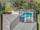 Aerial view of a home featuring a screened-in pool, complemented by lush landscaping and a brick-paved walkway at 328 Hamrick Dr, Kissimmee, FL 34759