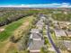 A high-angle view of a neighborhood with houses, golf course and lake at 328 Hamrick Dr, Kissimmee, FL 34759