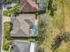 Bird's eye view of a home featuring a screened-in pool area and well-kept landscaping on a sunny day at 328 Hamrick Dr, Kissimmee, FL 34759