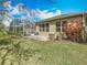 Green backyard showcasing a screened-in pool area, complemented by well-maintained lawn and garden beds at 328 Hamrick Dr, Kissimmee, FL 34759