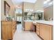 Long bathroom view showcasing double sinks, vanity, glass shower, soaking tub, and decoratively framed wall art at 328 Hamrick Dr, Kissimmee, FL 34759