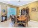 Classic dining room with a large wooden table, elegant china cabinet, and soft, natural light at 328 Hamrick Dr, Kissimmee, FL 34759