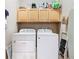 Laundry room with side-by-side white washer and dryer, cabinets and accessories at 328 Hamrick Dr, Kissimmee, FL 34759