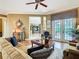 Living room with hardwood floors and plush seating next to French doors leading to the pool at 328 Hamrick Dr, Kissimmee, FL 34759