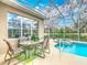 Screened-in patio with dining table, chairs and view of the pool area at 328 Hamrick Dr, Kissimmee, FL 34759