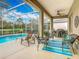 Well-appointed screened patio with lounge chairs, ceiling fan, and access to the pool at 328 Hamrick Dr, Kissimmee, FL 34759