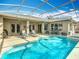 Refreshing screened-in pool with a spa, lounge chairs, and outdoor dining, ideal for enjoying sunny days at 328 Hamrick Dr, Kissimmee, FL 34759