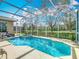 Beautiful screened pool and spa, surrounded by lush landscaping at 328 Hamrick Dr, Kissimmee, FL 34759