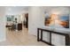 Entryway with neutral tile, a console table, and artwork, leading into the open-concept kitchen and living spaces at 430 Novi Path, Kissimmee, FL 34747