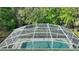 Aerial view of a large backyard pool with screened enclosure and surrounding greenery at 446 Reserve Dr, Davenport, FL 33896