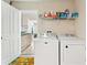 Practical laundry room featuring a washer, dryer, shelving, and an open doorway to the kitchen at 446 Reserve Dr, Davenport, FL 33896