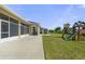 View of the backyard showcasing a screened lanai, playset, storage shed, and lush greenery at 4774 Rummell Rd, St Cloud, FL 34771