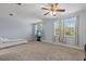 Bedroom featuring carpeting, a ceiling fan, and large windows overlooking the yard at 4774 Rummell Rd, St Cloud, FL 34771