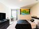 View of bedroom featuring dark bedding, dresser with TV, and large themed tapestry at 4823 Coral Castle Dr, Kissimmee, FL 34746