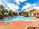 Beautiful community pool with ample lounge seating, palm trees, and clear blue water at 4823 Coral Castle Dr, Kissimmee, FL 34746