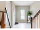 Bright entryway featuring tile flooring, coat rack, and staircase leading to the upper level at 4823 Coral Castle Dr, Kissimmee, FL 34746