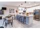 Open kitchen and dining area with stainless steel appliances, island seating, and modern pendant lights at 4823 Coral Castle Dr, Kissimmee, FL 34746